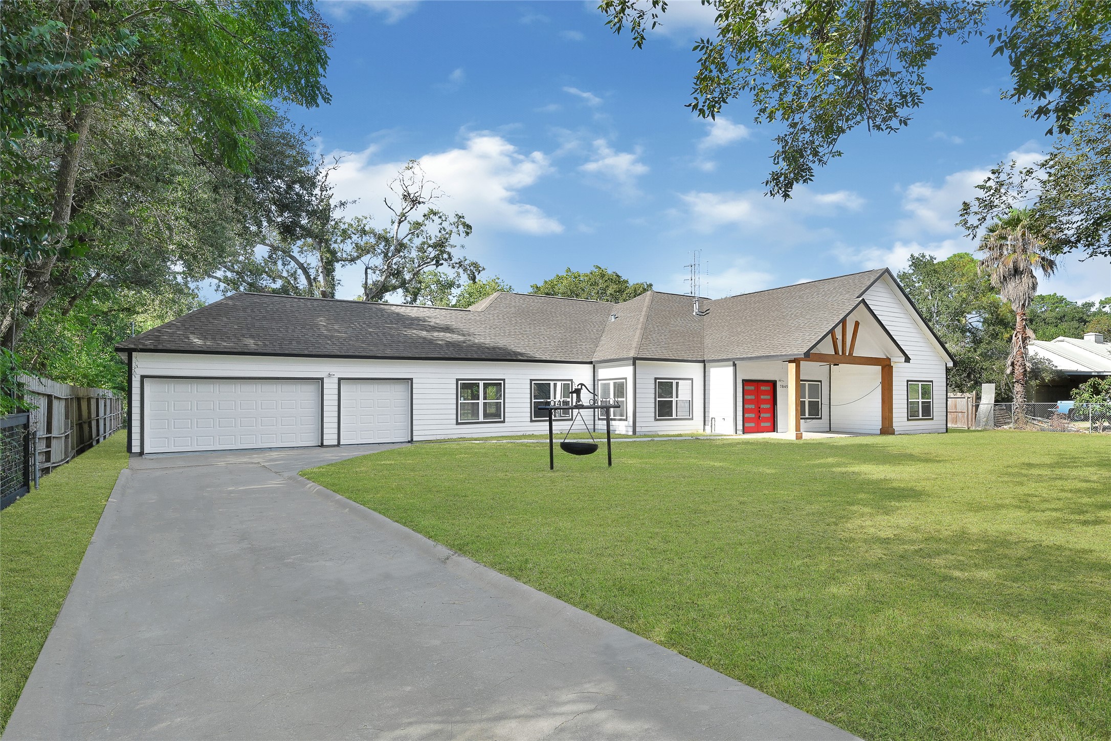 7045 Cayton Street Houston, TX 77061 - Photo 3 of 37 a front view of a house with a garden and trees