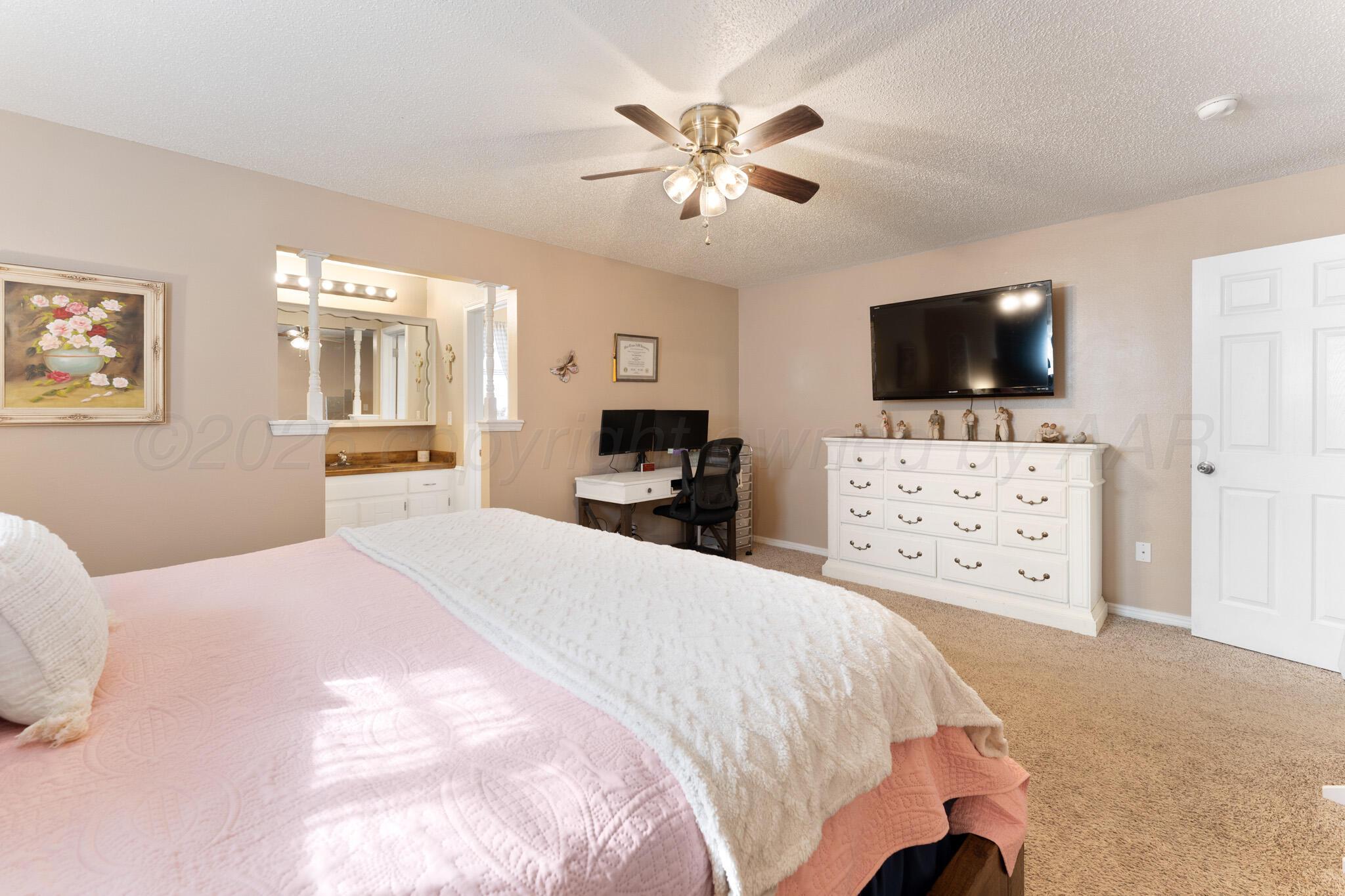6114 Cornell Street Amarillo, TX 79109 - Photo 15 of 33 a bedroom with a bed a mirror and a flat screen tv