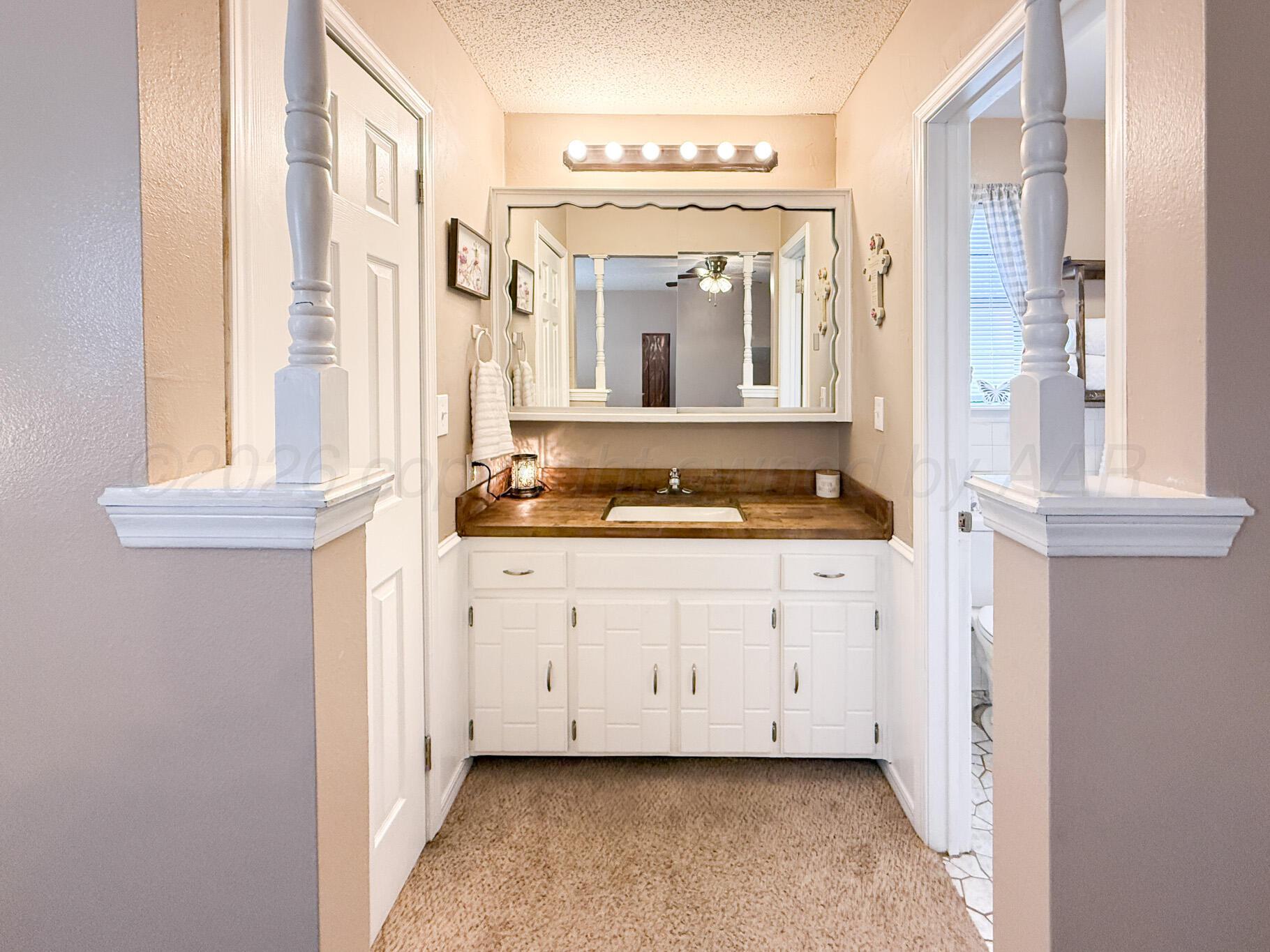 6114 Cornell Street Amarillo, TX 79109 - Photo 17 of 33 a bathroom with a granite countertop sink and a mirror
