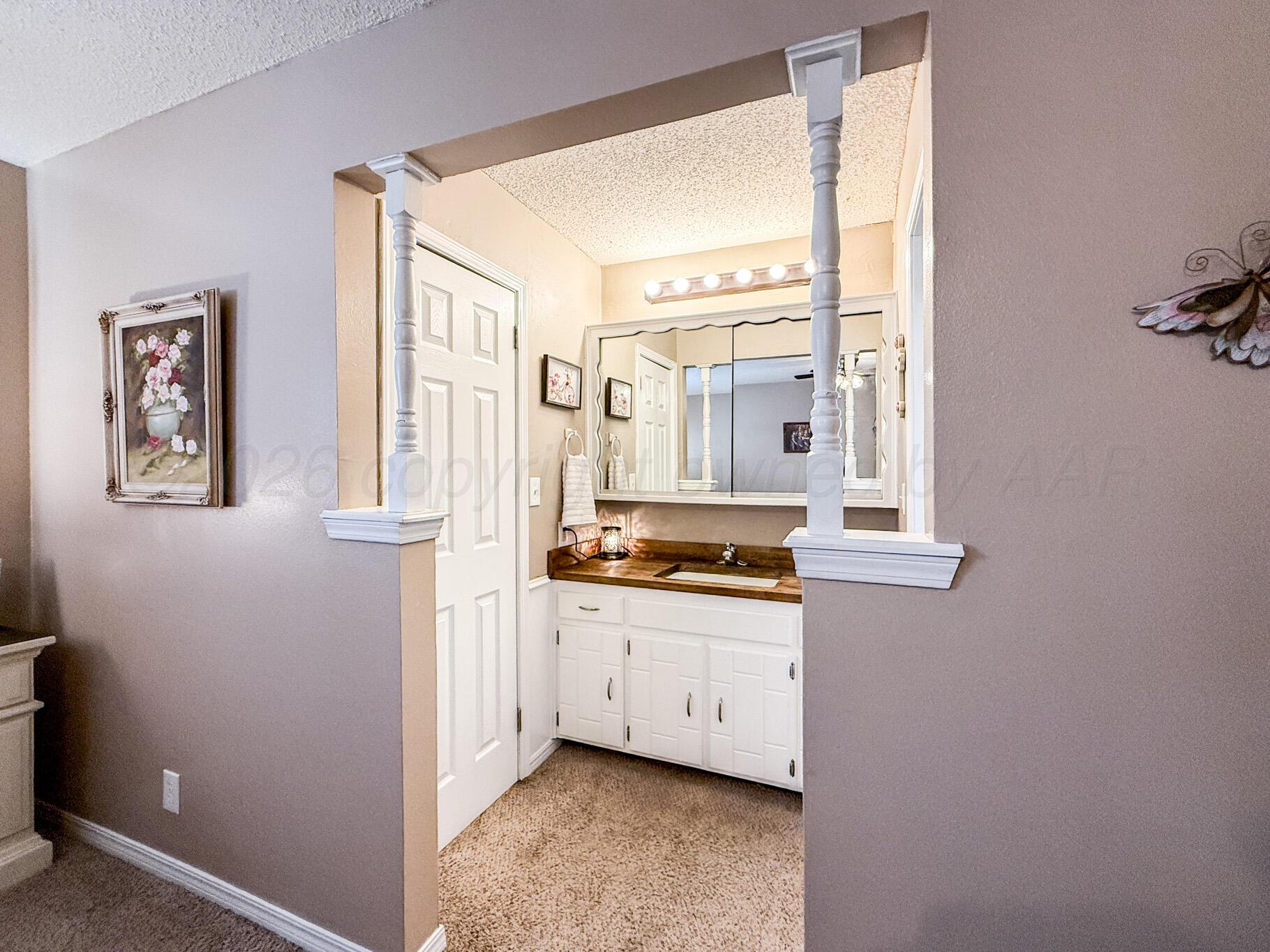 6114 Cornell Street Amarillo, TX 79109 - Photo 18 of 33 a spacious bathroom with a granite countertop sink a mirror and a bathtub
