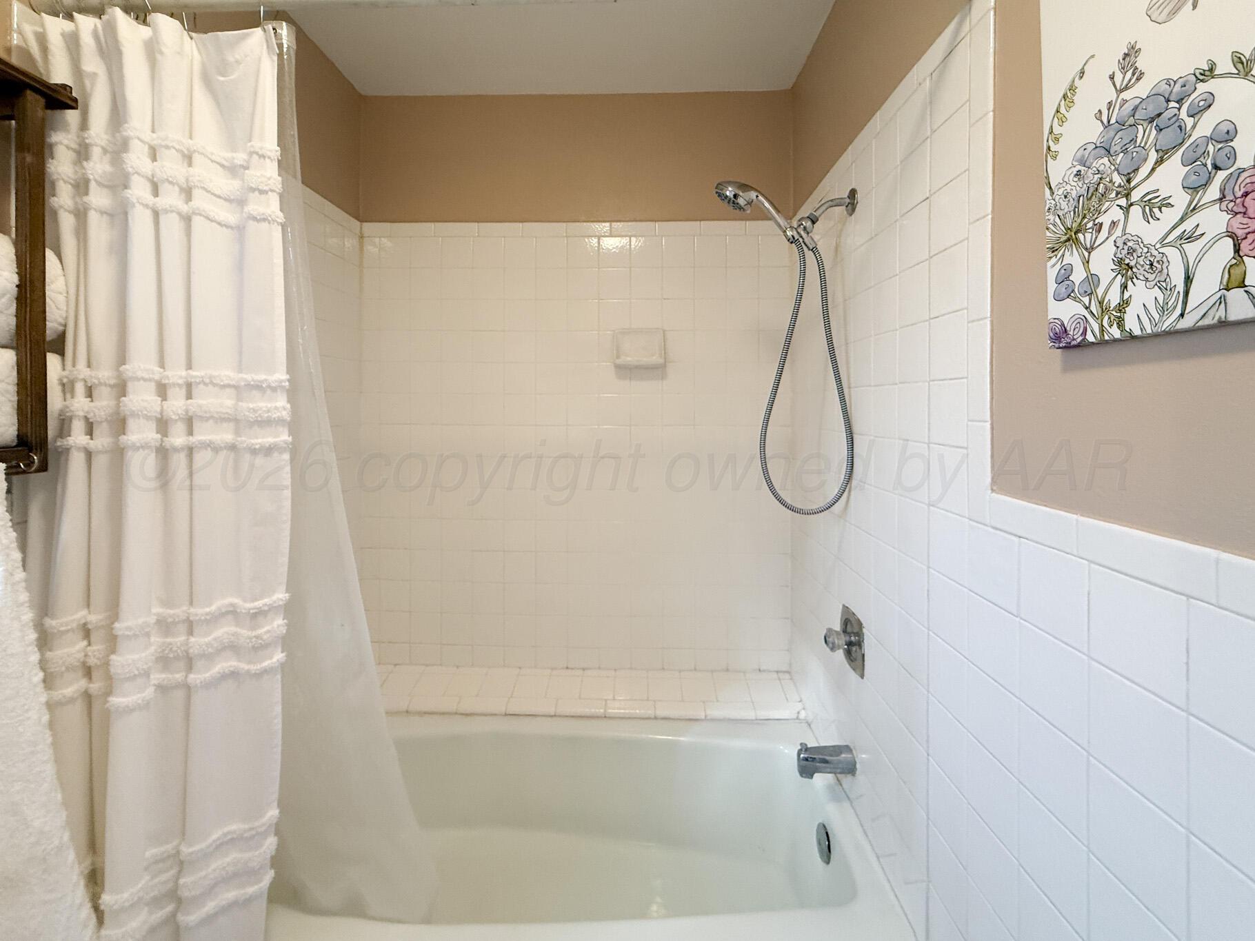 6114 Cornell Street Amarillo, TX 79109 - Photo 20 of 33 a bathroom with a bath tub with a shower