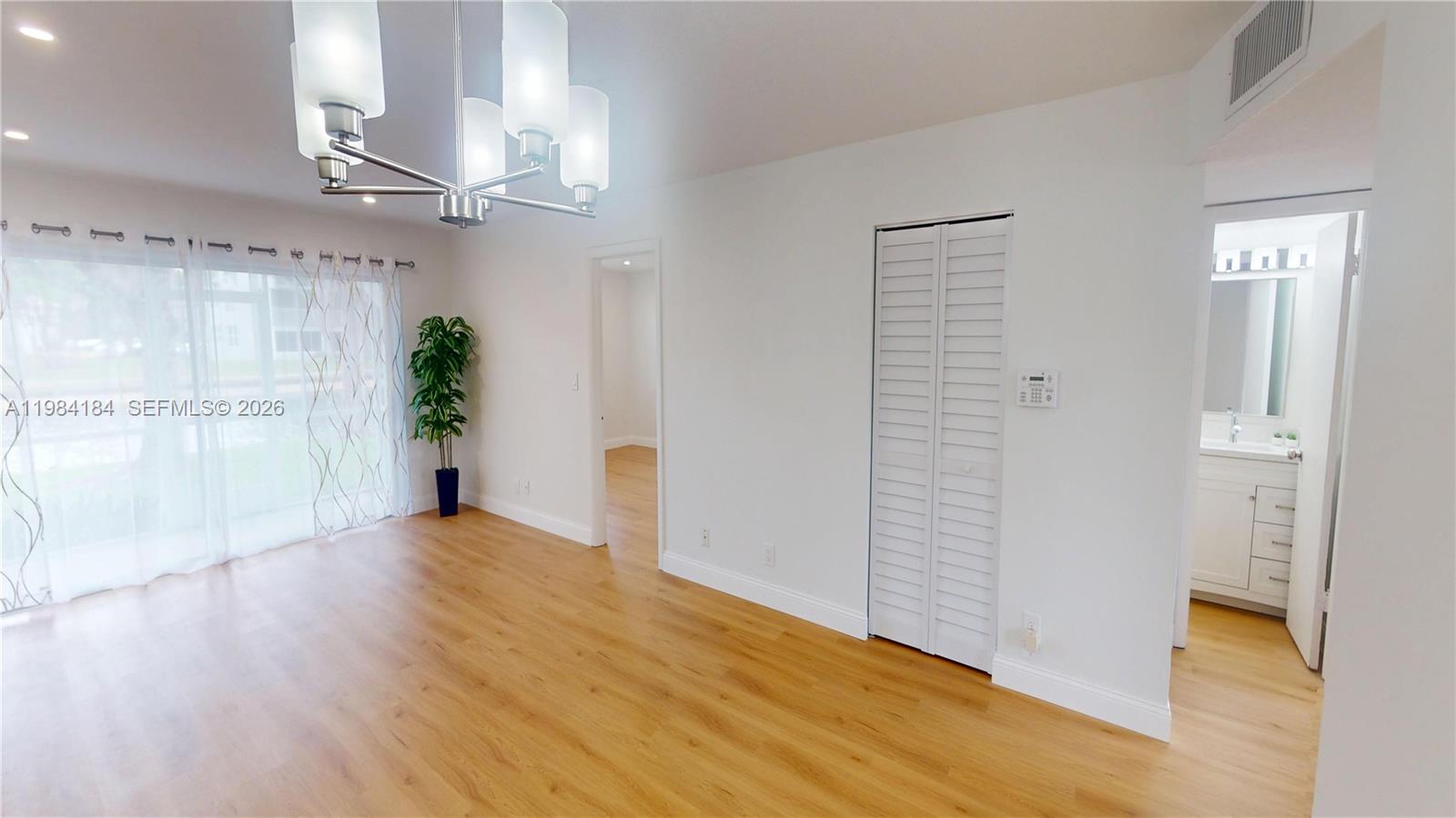 8846 West McNab Road, Unit 106 Tamarac, FL 33321 - Photo 13 of 39 wooden floor in an empty room with a window