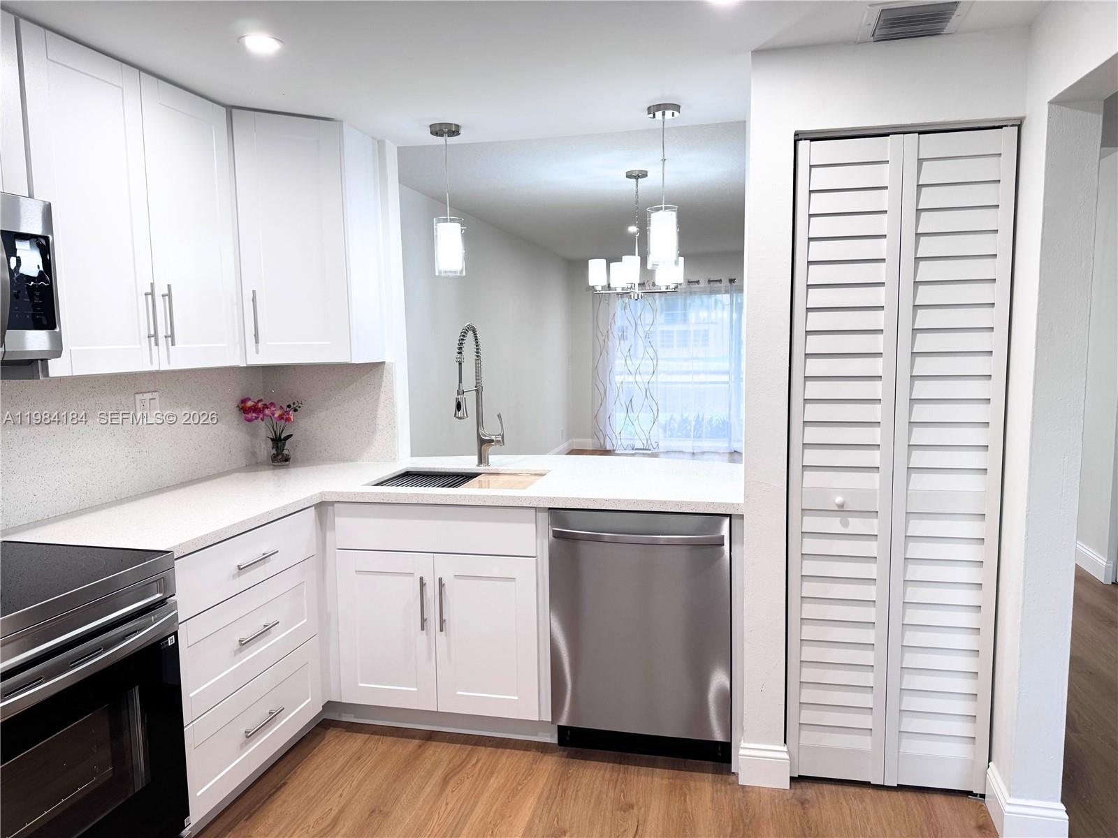 8846 West McNab Road, Unit 106 Tamarac, FL 33321 - Photo 16 of 39 a kitchen with granite countertop white cabinets and white appliances