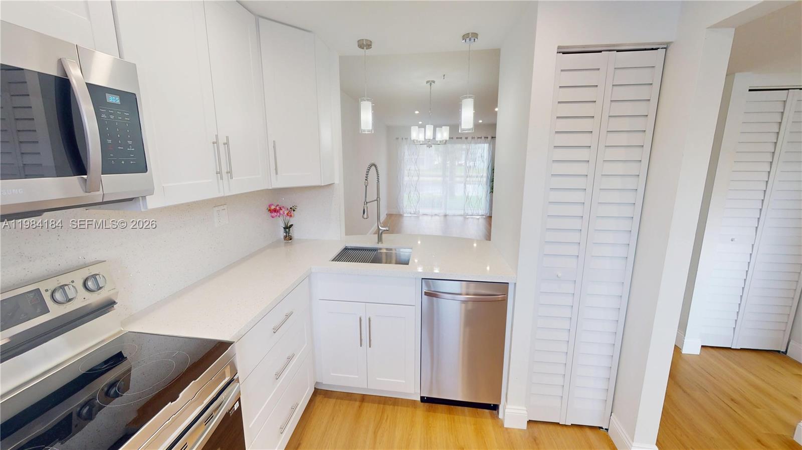 8846 West McNab Road, Unit 106 Tamarac, FL 33321 - Photo 17 of 39 a kitchen with a sink and wooden floor