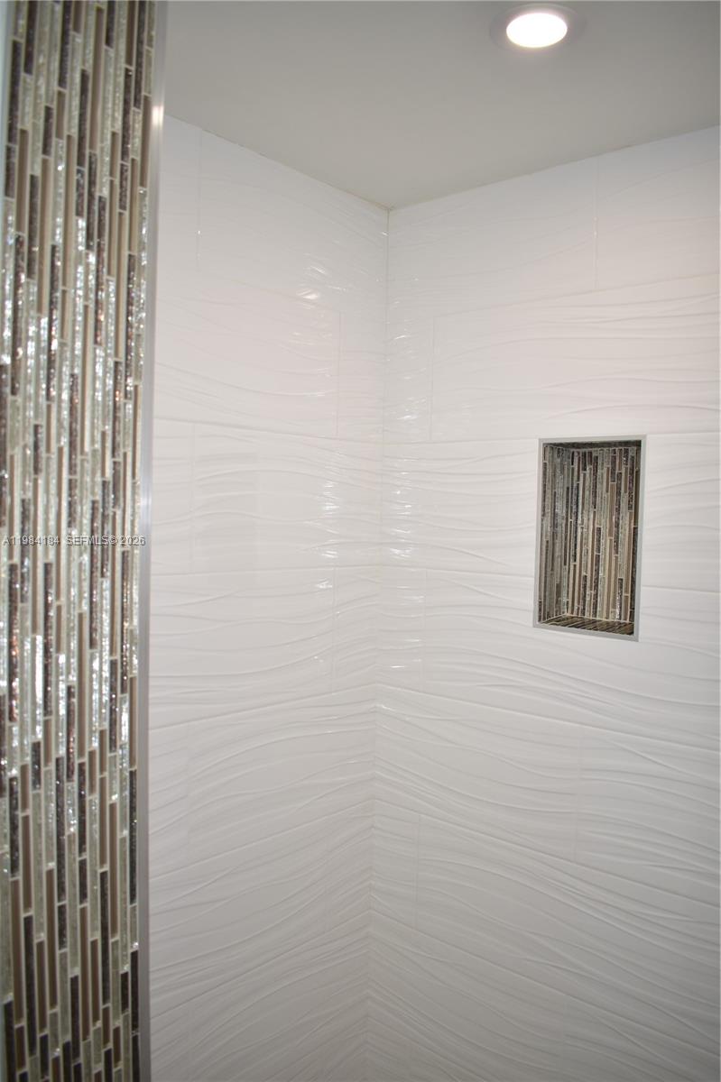 8846 West McNab Road, Unit 106 Tamarac, FL 33321 - Photo 26 of 39 a bathroom with a shower curtain
