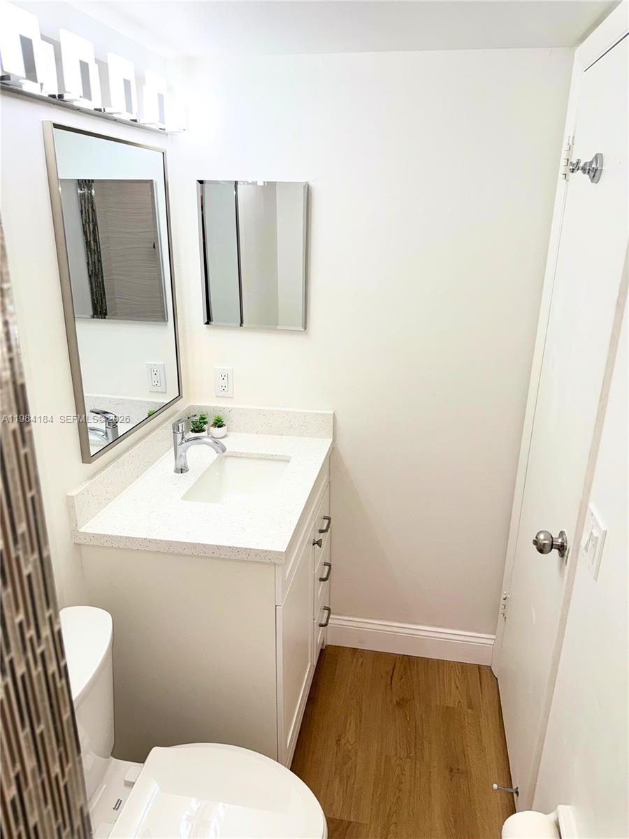 8846 West McNab Road, Unit 106 Tamarac, FL 33321 - Photo 27 of 39 a bathroom with a sink a toilet and mirror