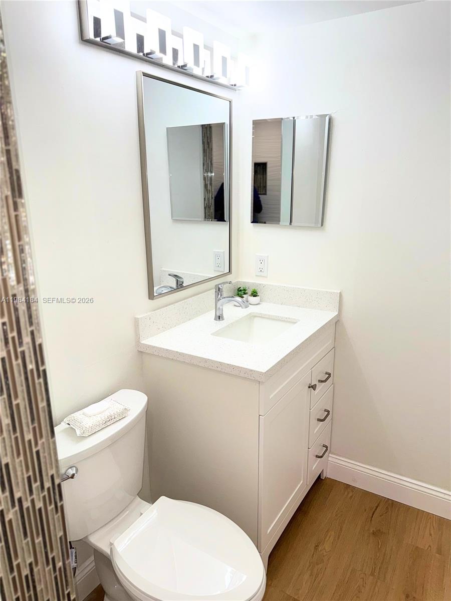 8846 West McNab Road, Unit 106 Tamarac, FL 33321 - Photo 29 of 39 a bathroom with a sink mirror vanity and toilet