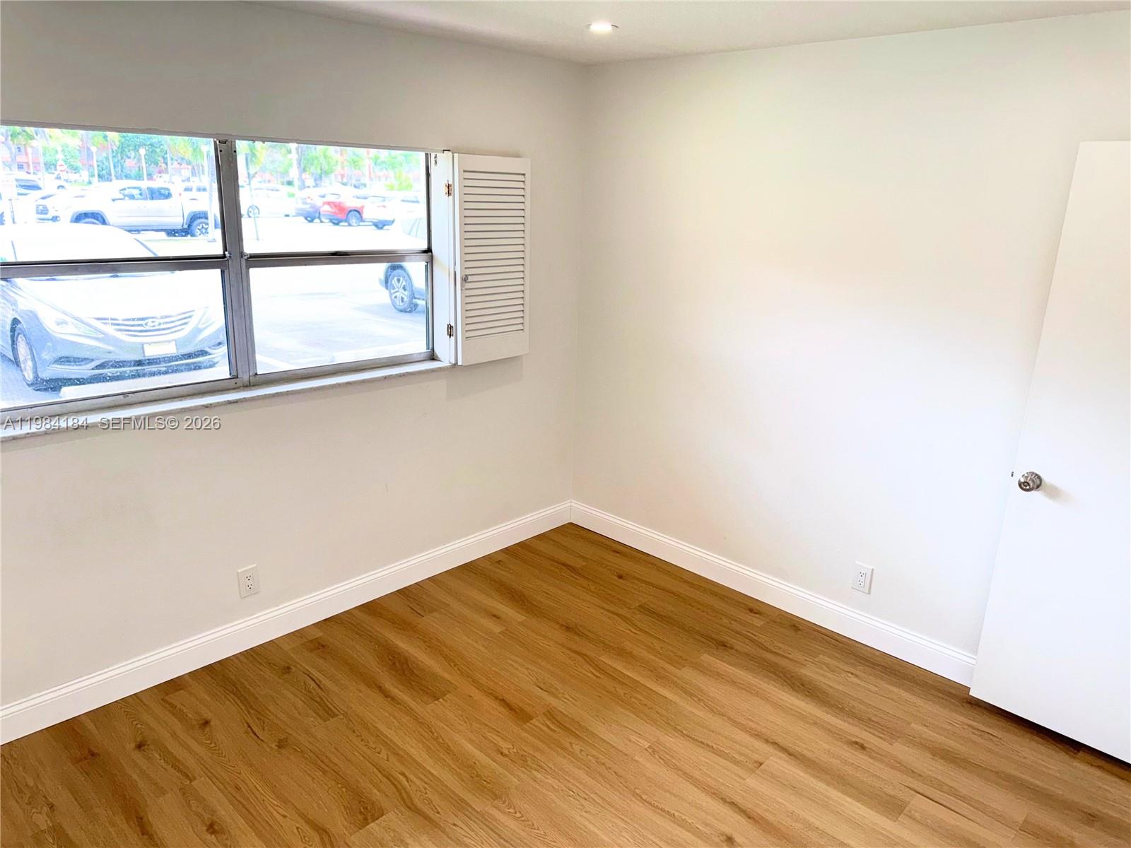8846 West McNab Road, Unit 106 Tamarac, FL 33321 - Photo 31 of 39 a view of empty room with wooden floor and fan