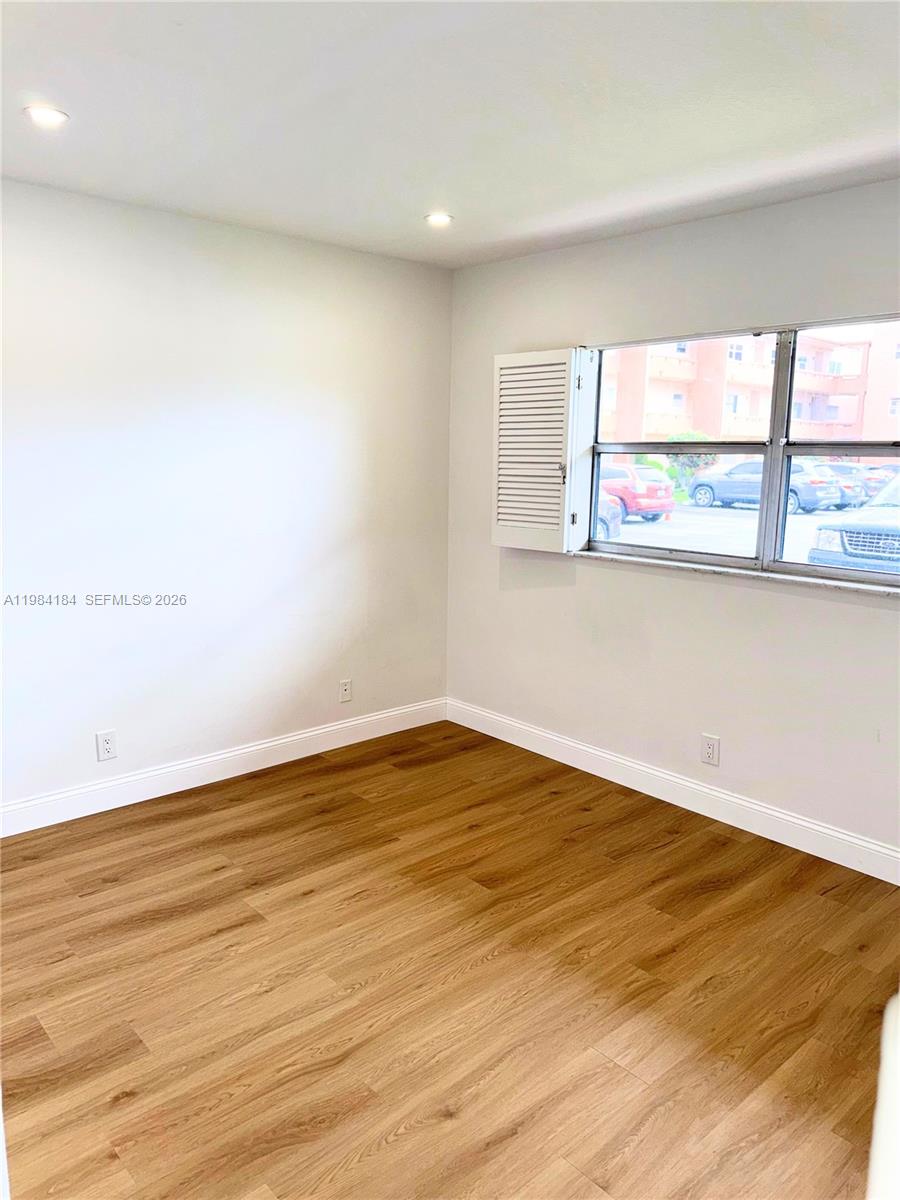 8846 West McNab Road, Unit 106 Tamarac, FL 33321 - Photo 33 of 39 wooden floor in an empty room with a window
