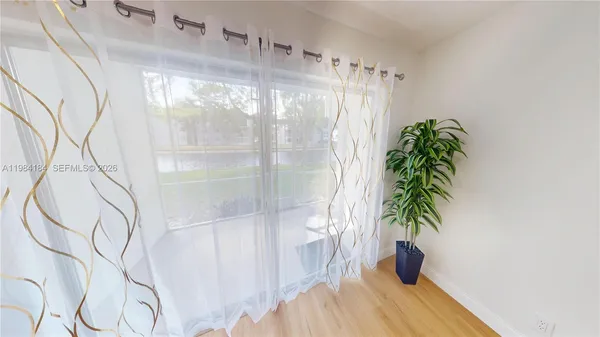 a view of a room with wooden floor and potted plant