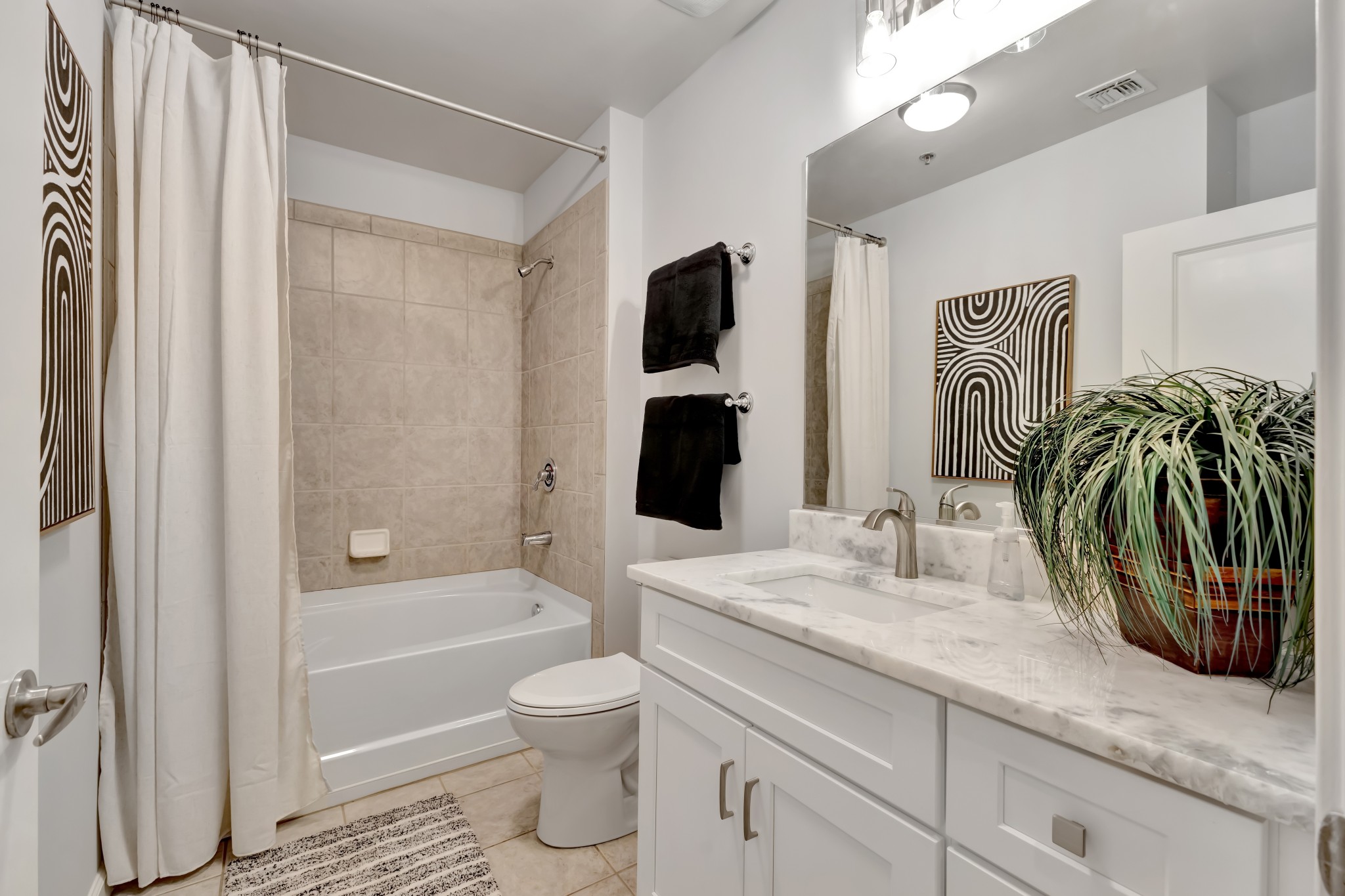 415 Church Street, Unit 1805 Nashville, TN 37219 - Photo 35 of 66 a bathroom with a granite countertop sink a toilet and bathtub