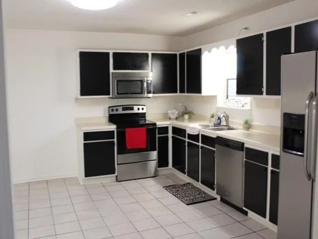 a large kitchen with cabinets and stainless steel appliances