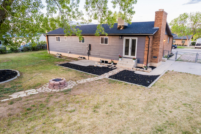 634 South 2100th Street West Vernal, UT 84078 - Photo 67 of 71 Rear exterior featuring a brick chimney, a double glass-panel door, and a concrete patio
