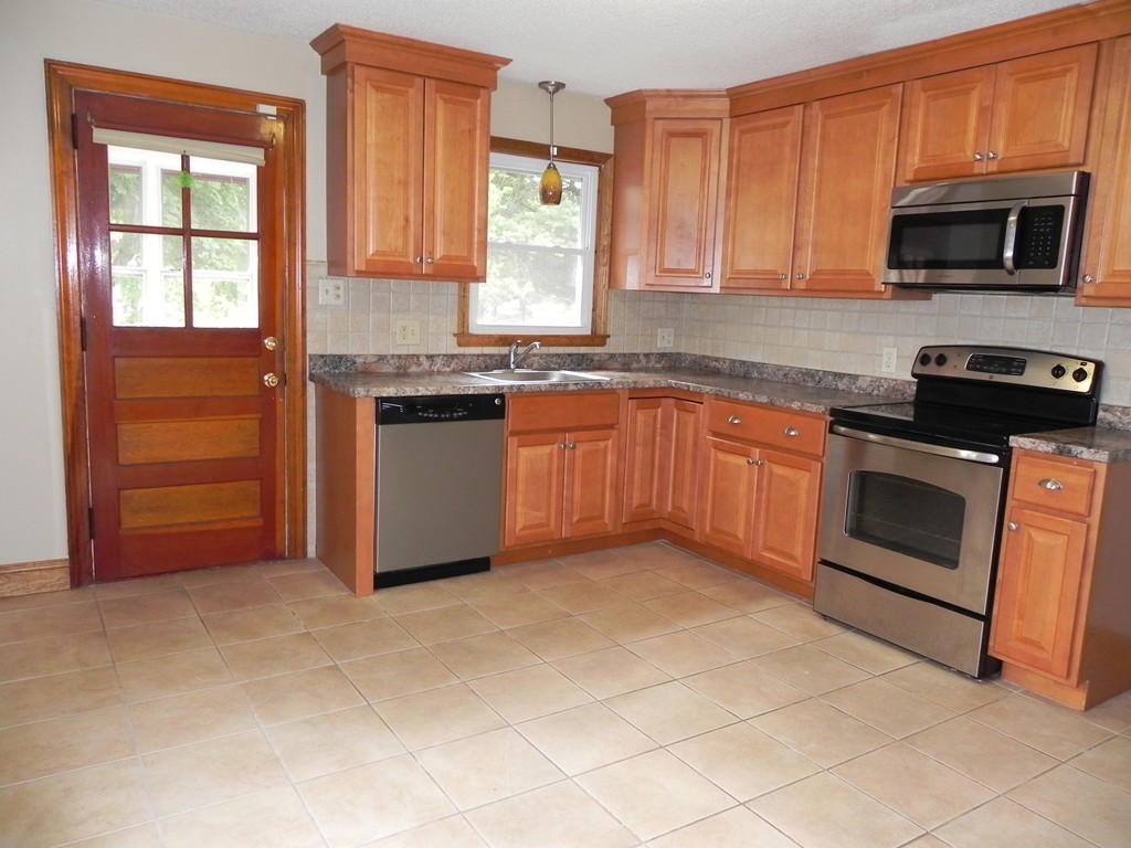 206 Parker Street Springfield, MA 01151 - Photo 2 of 21 a kitchen with granite countertop a sink cabinets stainless steel appliances and a window