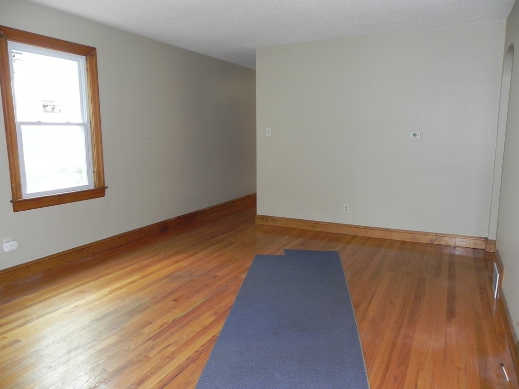 206 Parker Street Springfield, MA 01151 - Photo 5 of 21 a view of an empty room with wooden floor and a window