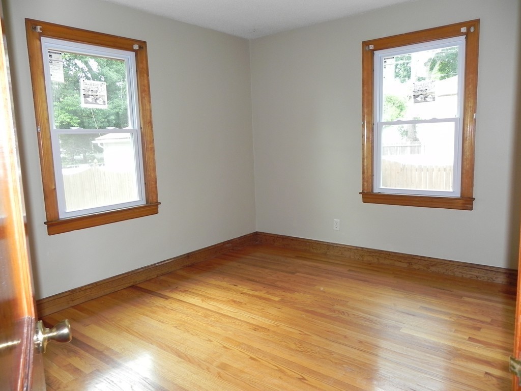 206 Parker Street Springfield, MA 01151 - Photo 10 of 21 an empty room with wooden floor and windows