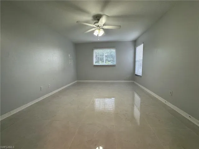 an empty room with a window and a fan