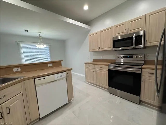 a kitchen with stainless steel appliances granite countertop a stove microwave and sink