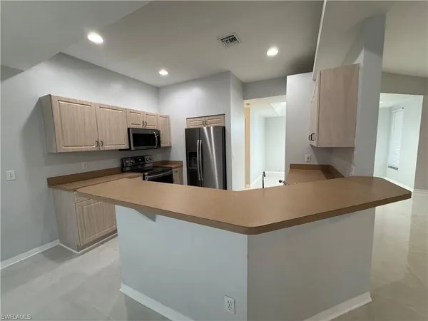 a kitchen with stainless steel appliances a refrigerator sink and microwave