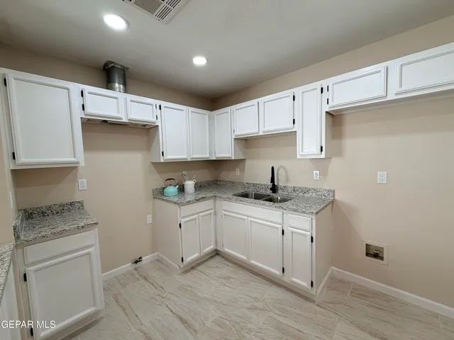 a kitchen with stainless steel appliances a sink stove and cabinets