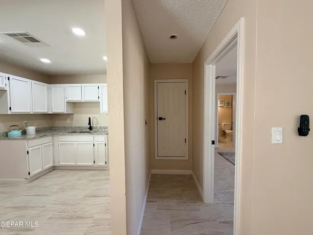 a kitchen with a refrigerator and white cabinets