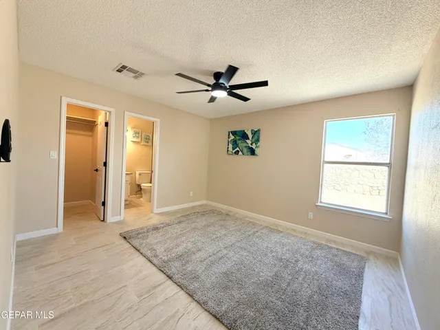 an empty room with fan and windows