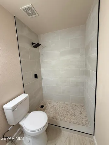 a white toilet sitting next to a shower