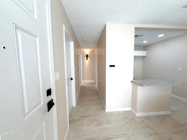a view of a hallway with wooden floor and cabinet