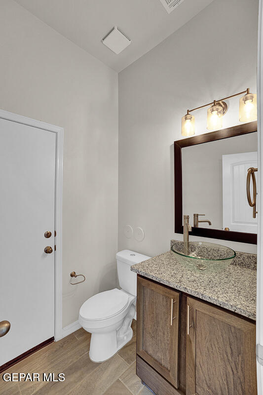 6943 Levee Circle Anthony, NM 88021 - Photo 15 of 36 a bathroom with a granite countertop toilet sink and mirror