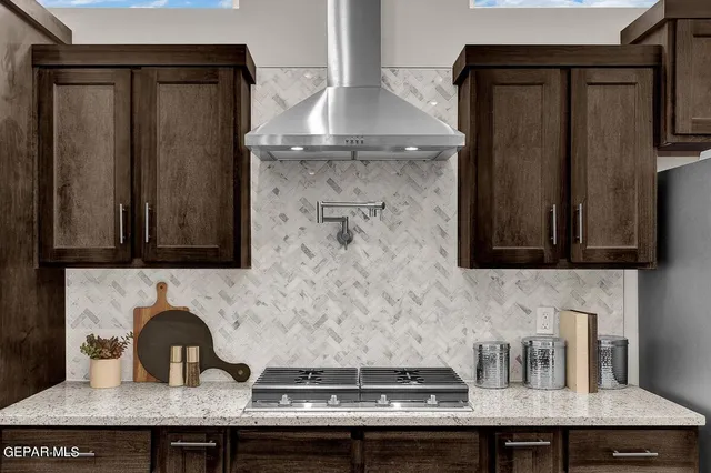 a kitchen with a stove a counter space dining table and chairs