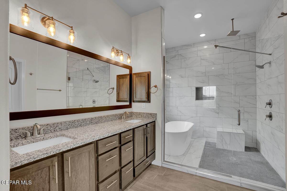 6943 Levee Circle Anthony, NM 88021 - Photo 20 of 36 a bathroom with a granite countertop sink toilet a mirror and shower
