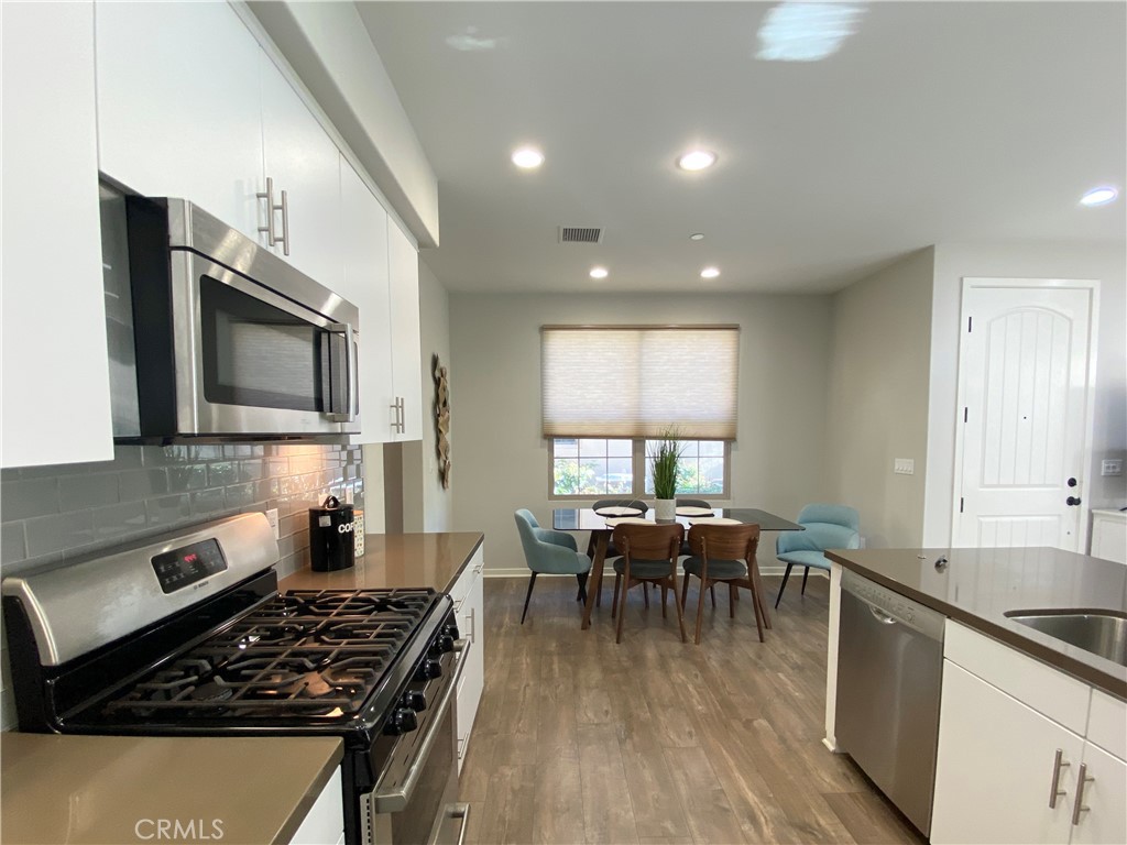 57 Bronze Leaf Irvine, CA 92620 - Photo 8 of 35 a kitchen with a stove a sink and a microwave