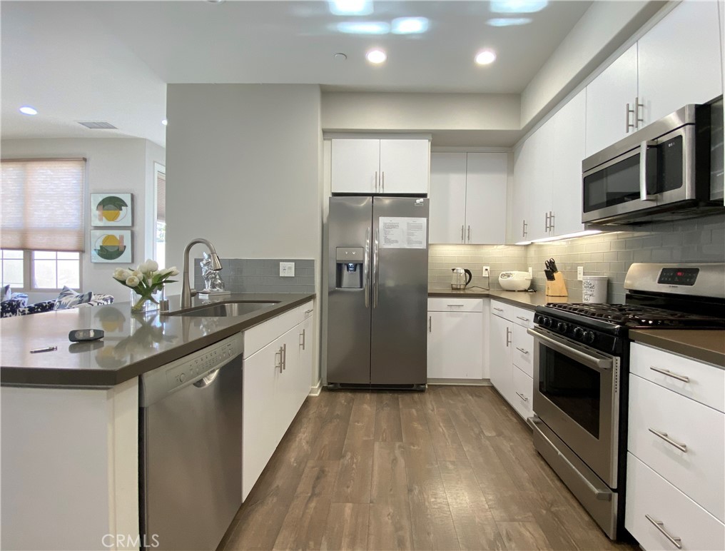 57 Bronze Leaf Irvine, CA 92620 - Photo 9 of 35 a kitchen with stainless steel appliances granite countertop a sink stove and refrigerator