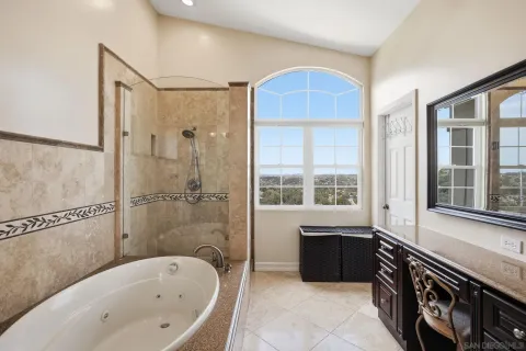 a bathroom with a tub sink shower and mirror