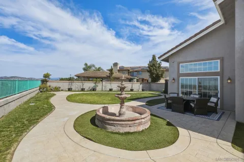 a view of a house with backyard sitting area and a garden