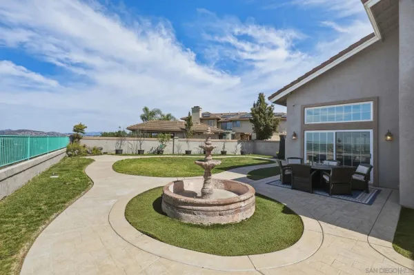 a view of a house with backyard sitting area and a garden