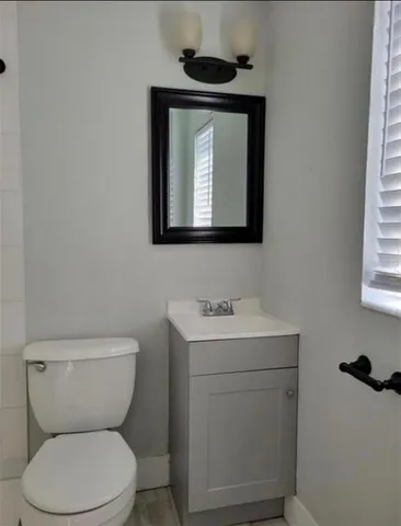 a bathroom with a toilet a sink and a mirror