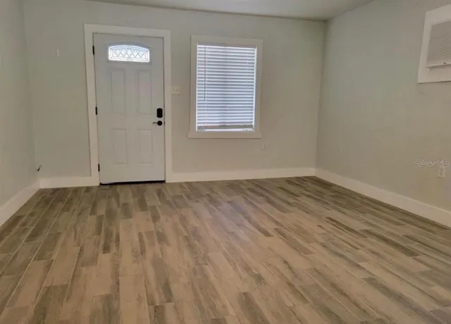 a view of a room with wooden floor and window