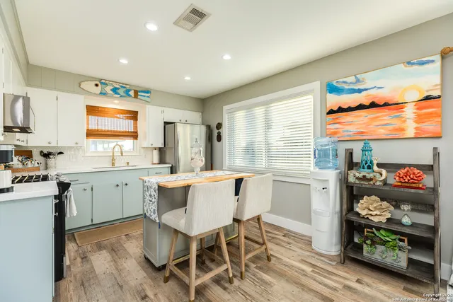 a kitchen with stainless steel appliances granite countertop a refrigerator a stove a sink and a microwave