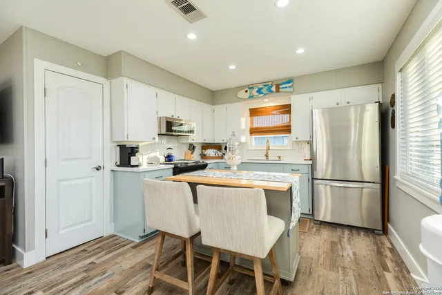 a kitchen with a sink stove top oven and cabinets