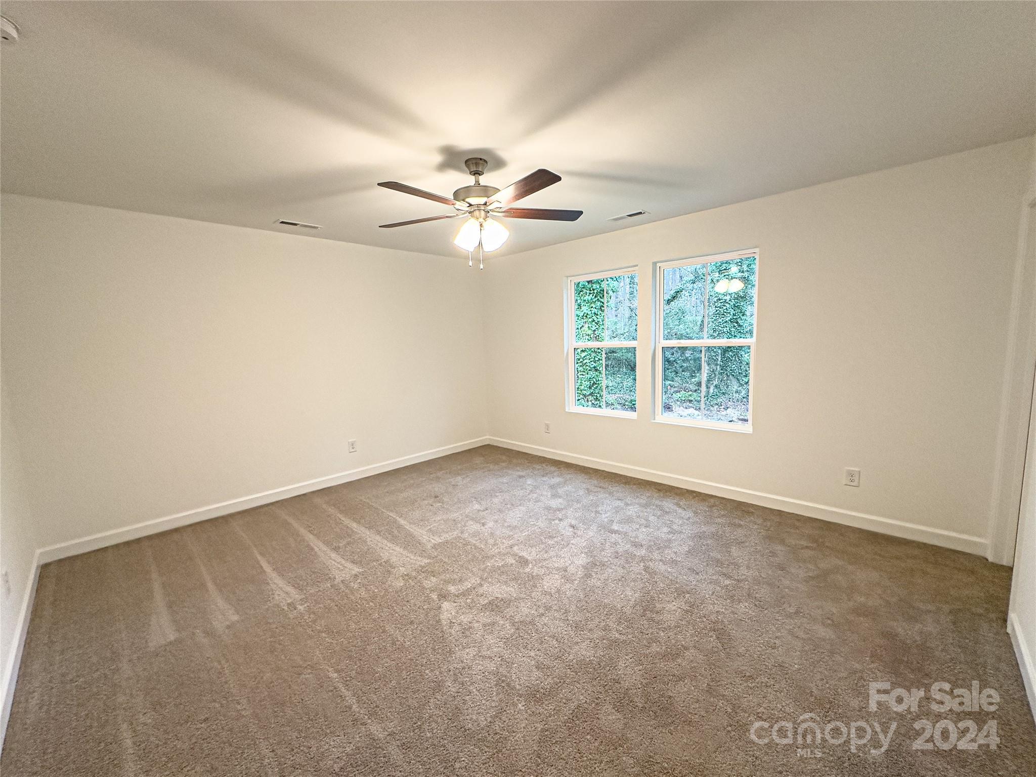 650 Sedgefield Street Southwest Concord, NC 28025 - Photo 12 of 15 an empty room with windows and ceiling fan