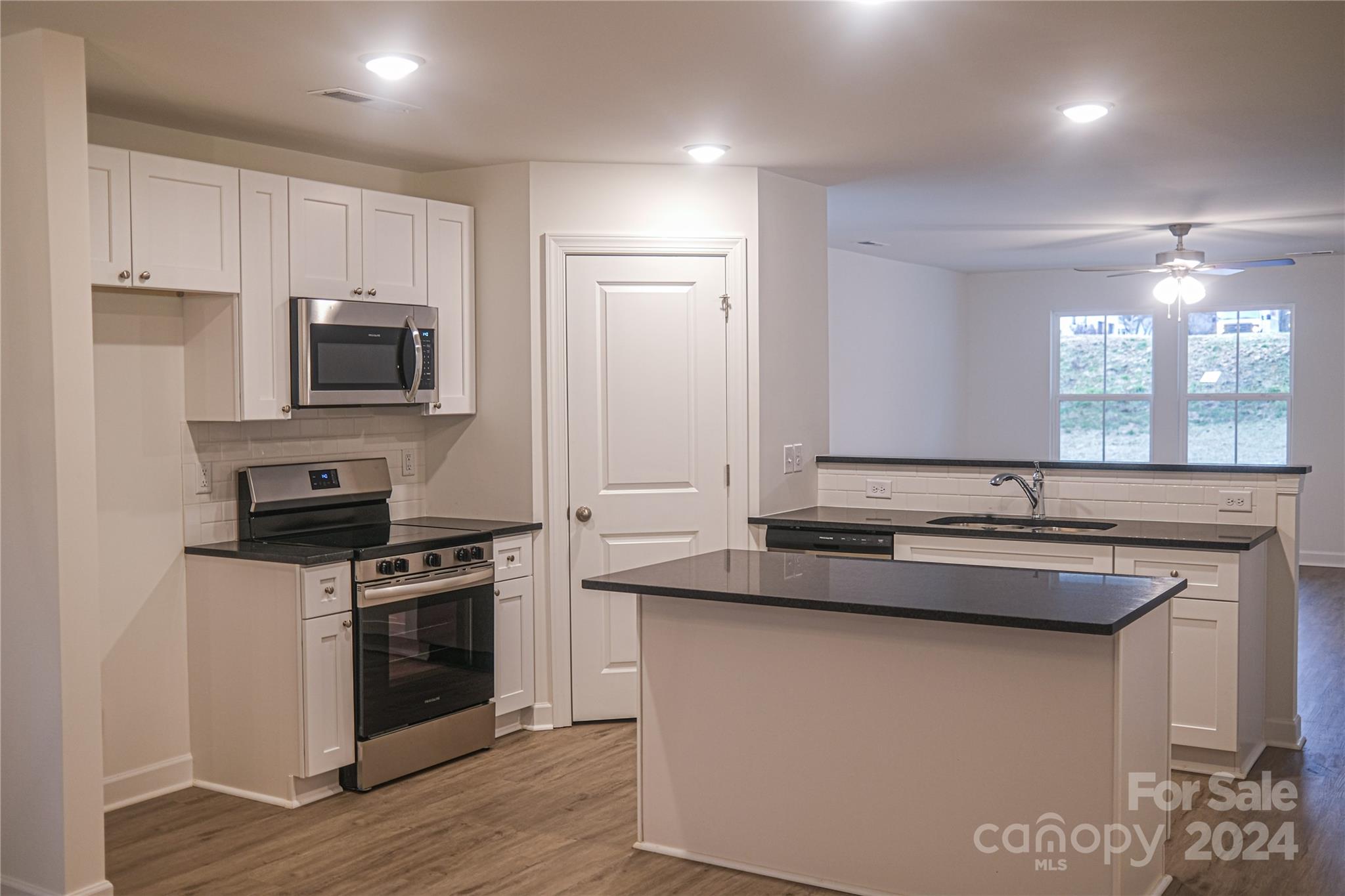 650 Sedgefield Street Southwest Concord, NC 28025 - Photo 2 of 15 a kitchen with stainless steel appliances granite countertop a stove a sink and a microwave