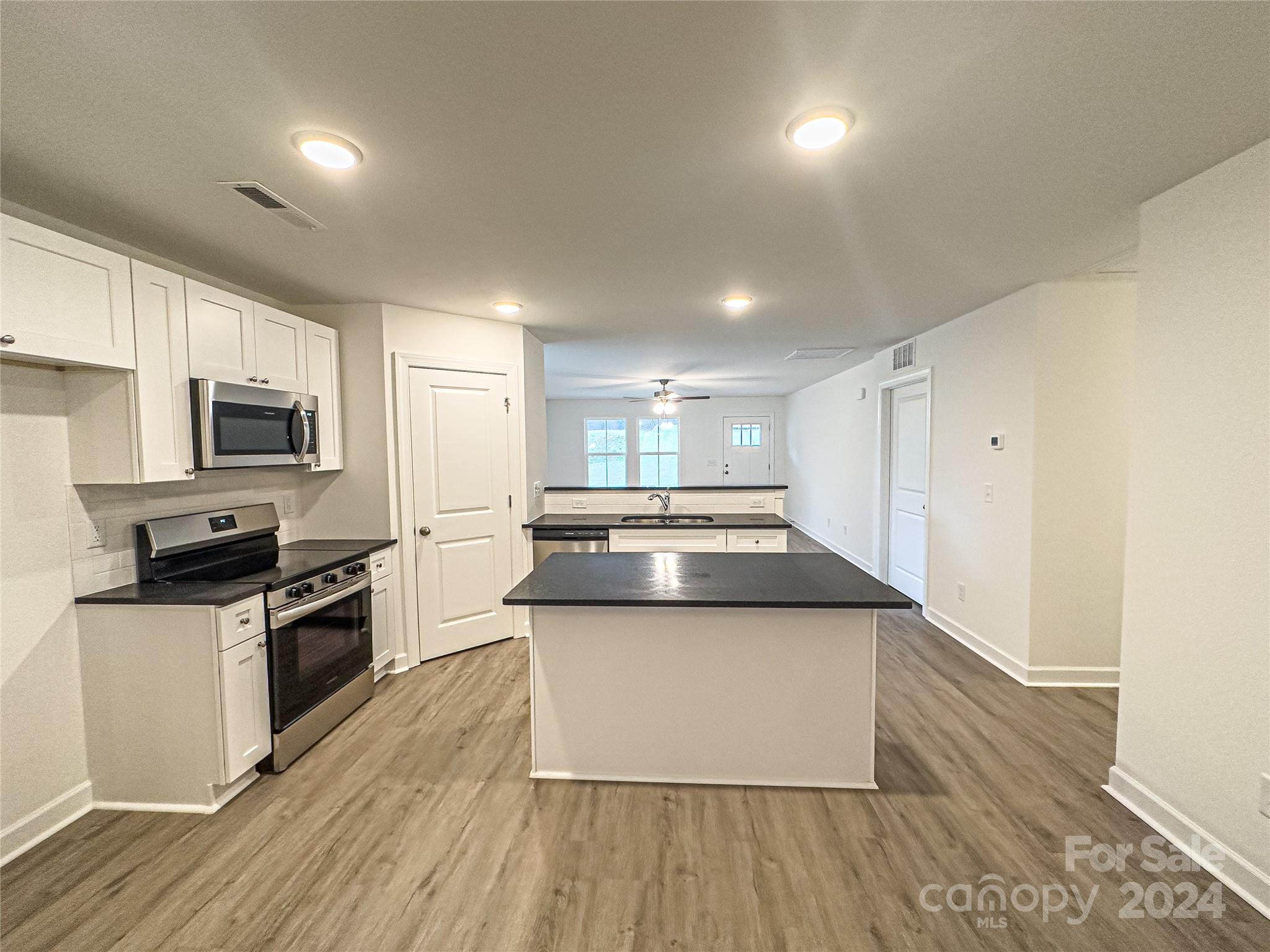 650 Sedgefield Street Southwest Concord, NC 28025 - Photo 6 of 15 a kitchen with wooden floor and steel appliances