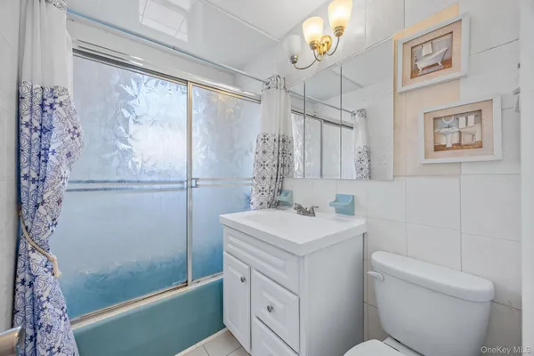 a bathroom with a sink a toilet a shower and a mirror