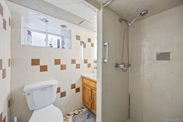 a white toilet sitting next to a bathroom sink and a shower