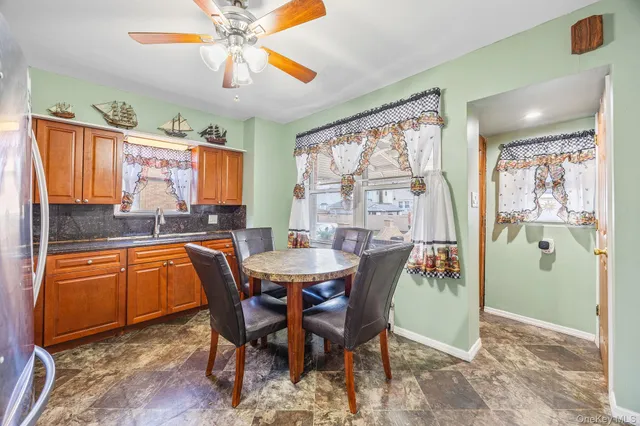 a dining room with stainless steel appliances a table and chairs