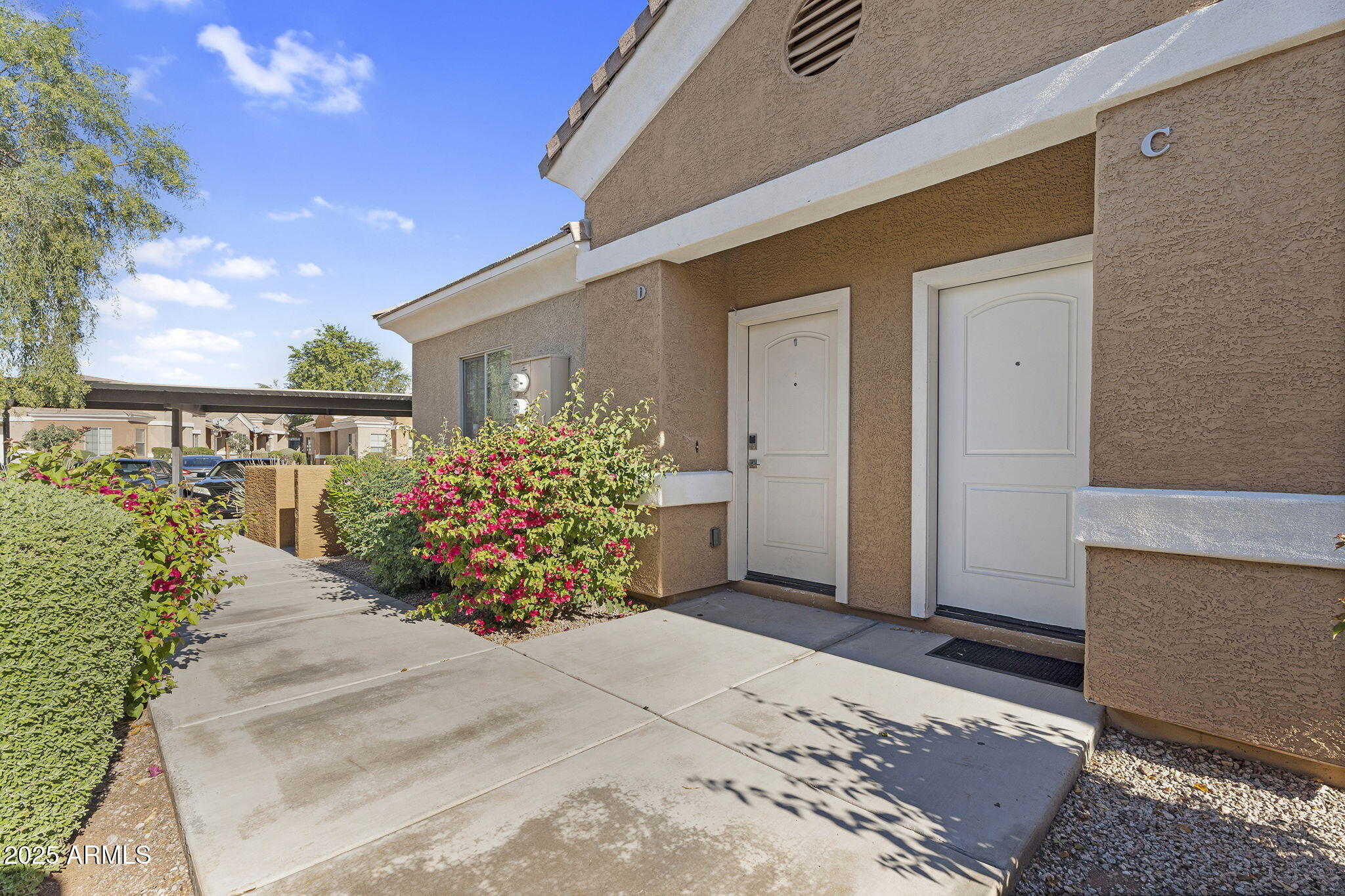 854 South San Marcos Drive, Unit 7C Apache Junction, AZ 85120 - Photo 1 of 48 a front view of a house with lots of flowers