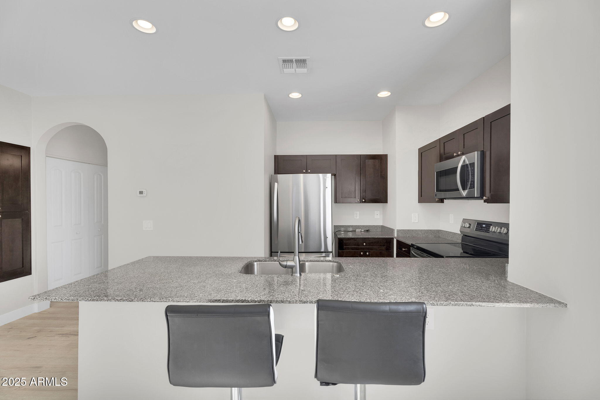 854 South San Marcos Drive, Unit 7C Apache Junction, AZ 85120 - Photo 9 of 48 a kitchen with stainless steel appliances granite countertop a sink and a refrigerator