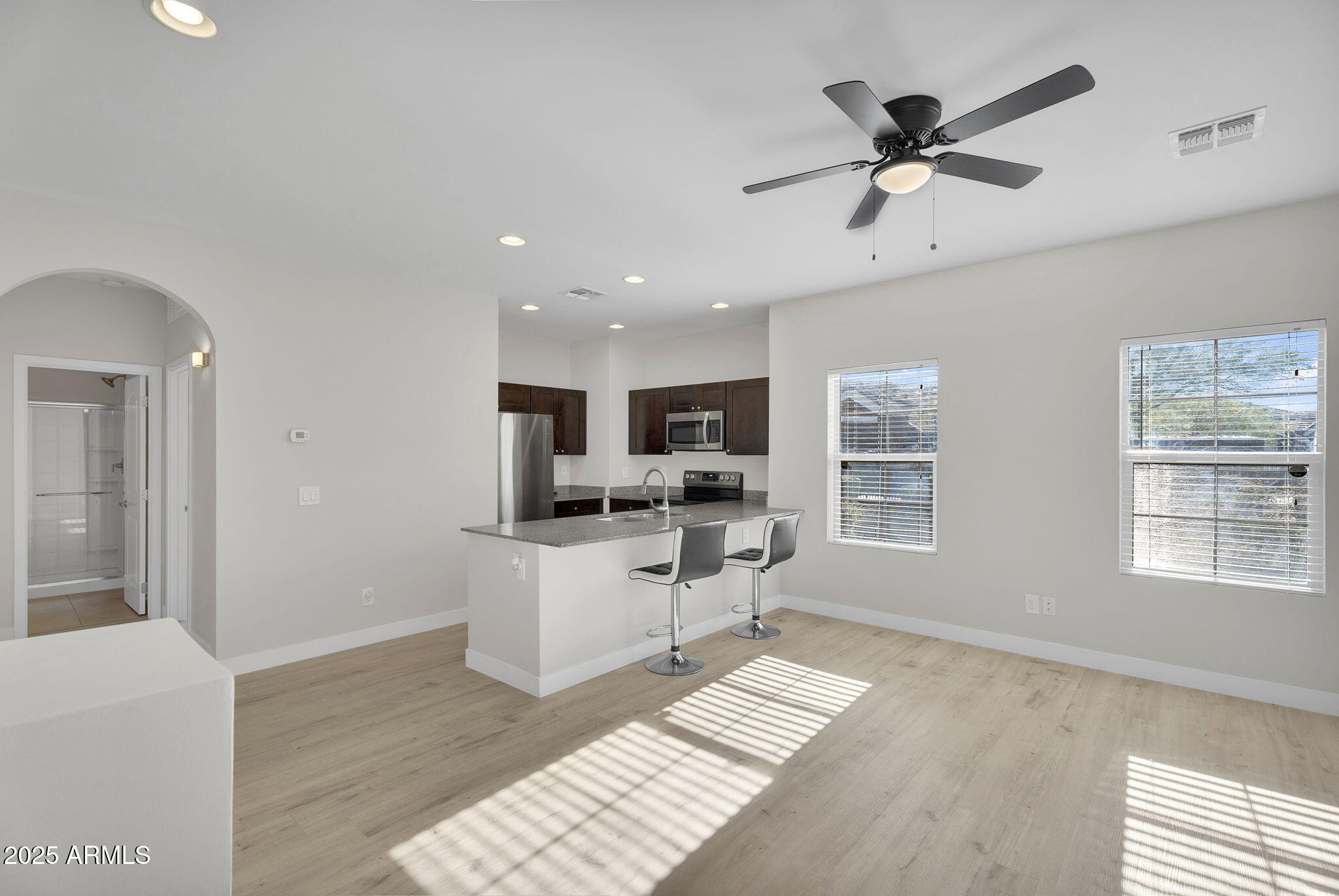 854 South San Marcos Drive, Unit 7C Apache Junction, AZ 85120 - Photo 5 of 48 a living room with stainless steel appliances kitchen island granite countertop a stove top oven a sink a dining table and chairs with wooden floor