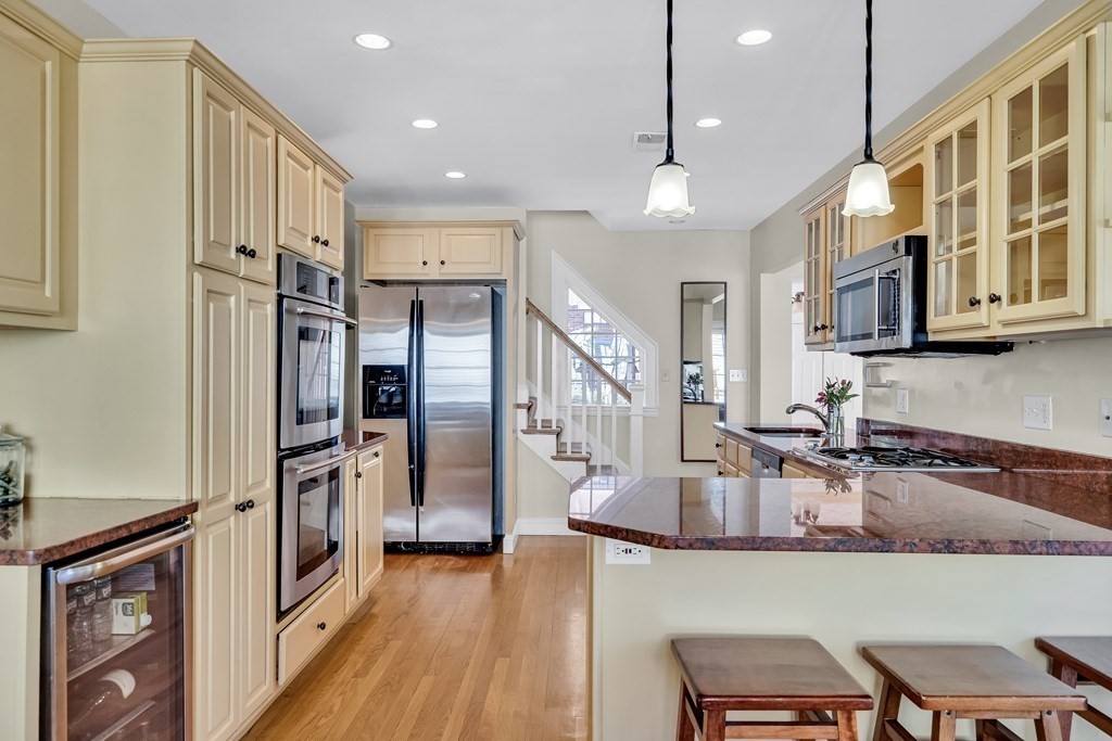 36 Sunset Road Wellesley, MA 02482 - Photo 6 of 30 a kitchen with stainless steel appliances granite countertop a refrigerator a sink dishwasher a stove and a dining table with wooden floor